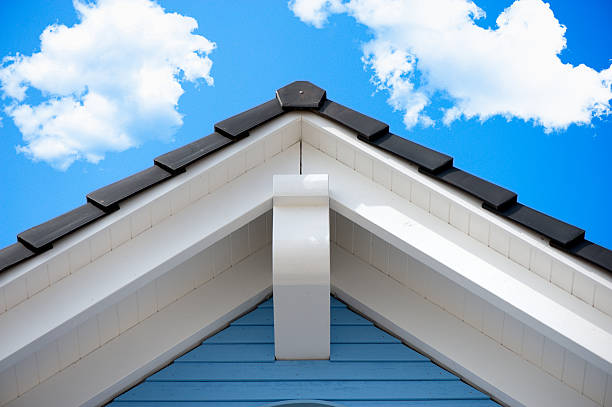 Detail of an house roof in the summer Detail of a house roof in front of a blue sky, with beautiful clouds gable stock pictures, royalty-free photos & images