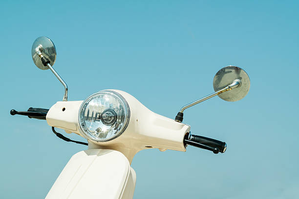 Detail of classic scooter with headlamp and handlebar against sk stock photo