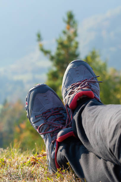 Detail of legs of a female hiker resting in grass and enjoying the view stock photo