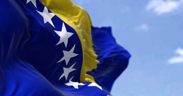 Detail of the national flag of Bosnia and Herzegovina waving in the wind on a clear day. stock photo