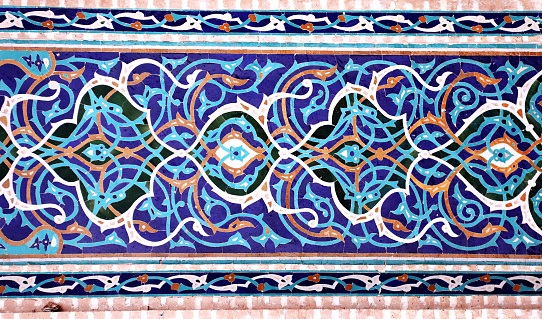 Detail of traditional persian mosaic wall with floral ornament, Grand Jame Mosque (Masjid-e Jameh Mosque, Friday Mosque), Yazd, Iran. Wall with ceramic tile of blue, cian, brown and white colors