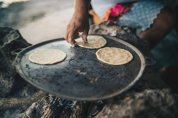 detail of woman preparing fresh tortillas on an open fire - efeito panning imagens e fotografias de stock