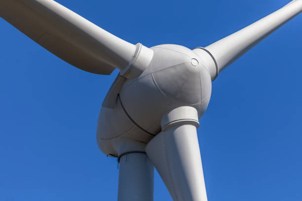 Detailed close up view of a wind turbines; generator, rotor and blade view on blue sky background stock photo