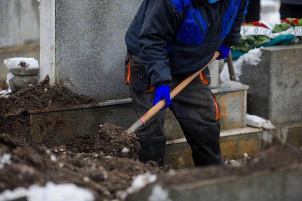 details of a gravedigger covering a tomb with dirt with a shovel during a burial ceremony on a cold and snowy winter day. - covid cemiterio imagens e fotografias de stock