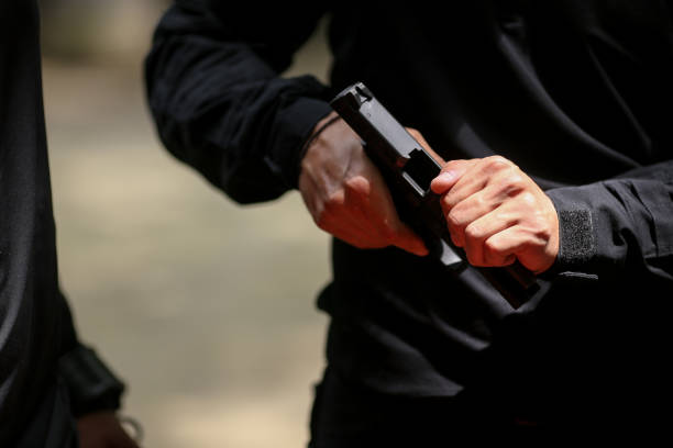 9 mm 'lik tabancayı ele alan bir adamın elleriyle detayları - gun violence stok fotoğraflar ve resimler