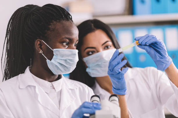 detectie van de coronavirusinfectie van pathogene in het microbiologielaboratorium - arts vrouw mondkapje stockfoto's en -beelden