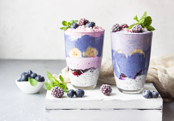 Detox layered smoothie made of different berries, fruits and chia pudding in glasses. Vegan dessert. Healthy vegetarian breakfast, dieting, weight loss food. stock photo