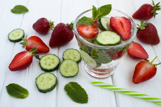 Detox or infused water  with strawberry and cucumber  on the  white wooden background. Close-up. stock photo