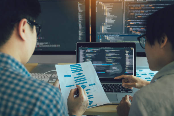 Developing programming and coding technologies working in a software engineers developing applications together in office. stock photo