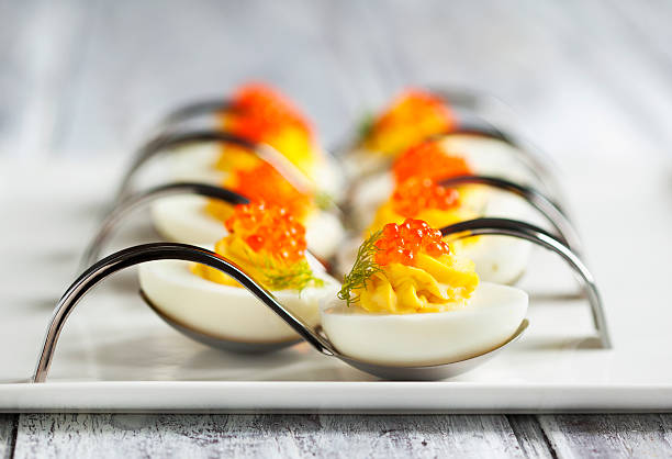 Deviled eggs with red caviar in a spoon stock photo