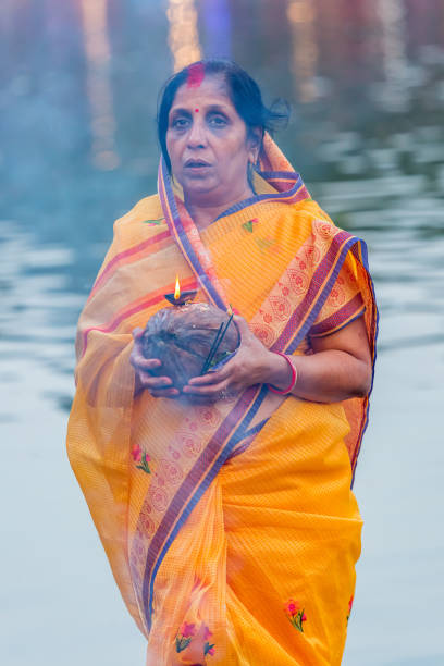 Devotee offering prayers to God During Chhath Puja Festival Kathmandu,Nepal - November 1,2019: Hindu devotee offering prayers to sun god standing in water according to hindu rituals during Chhath Puja Festival in Kathmandu. Chath Puja rituals chhath stock pictures, royalty-free photos & images