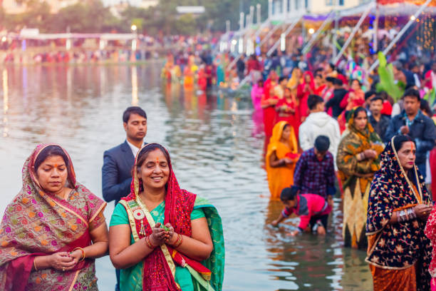 Devotees offering prayers to God During Chhath Puja Festival Kathmandu,Nepal - November 1,2019: Hindu devotees offering prayers to sun god standing in water according to hindu rituals during Chhath Puja Festival in Kathmandu. Chath Puja rituals chhath stock pictures, royalty-free photos & images