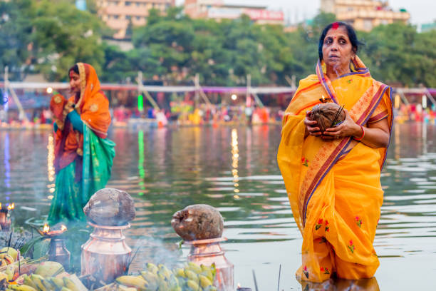 Devotees offering prayers to God During Chhath Puja Festival Kathmandu,Nepal - November 1,2019: Hindu devotees offering prayers to sun god standing in water according to hindu rituals during Chhath Puja Festival in Kathmandu. Chath Puja rituals chhath stock pictures, royalty-free photos & images