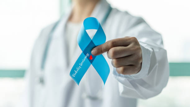 Diabetes Awareness ribbon for World diabetes day with red blood drop on blue bow color in doctor hand for supporting patient with diabetic disease Diabetes Awareness ribbon for World diabetes day with red blood drop on blue bow color in doctor hand for supporting patient with diabetic disease diabetes awareness month stock pictures, royalty-free photos & images