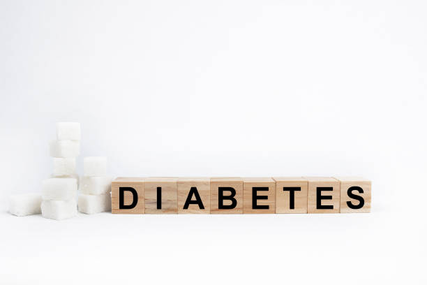 diabetes writing on wooden cubes and sugar on a white background. stock photo