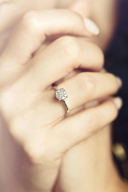 Diamond Ring In Woman's Hand Diamond Ring In Woman's Hand gold ring on finger stock pictures, royalty-free photos & images
