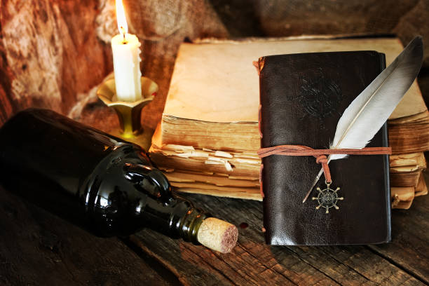 diary and feather with a bottle of rum romance novel pirate stock pictures, royalty-free photos & images