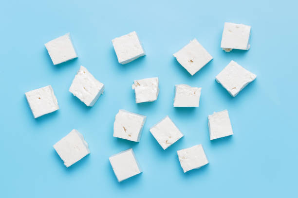 A diced pieces of tofu on blue background top view. stock photo