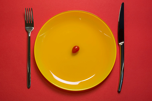 diet-concept-plate-top-view-cherry-tomato-on-yellow-empty-plate-with-picture-id1067137492