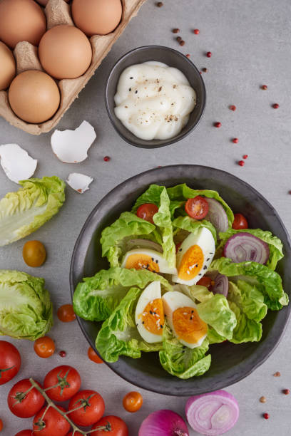 Diet menu. Healthy salad of fresh vegetables - tomatoes, egg, Onion. high angle view of a nutritious vegetable salad with boiled egg slices, served.  Healthy meal concept. stock photo