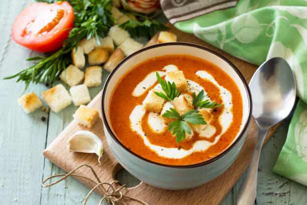 Diet menu. Puree soup tomato with croutons and cream in a bowl on a kitchen wooden table. The concept of healthy eating. stock photo