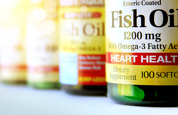 dietary supplements San Diego, USA - August 4, 2013: Bottles of fish oil dietary supplement in a row at pharmacy fish oil stock pictures, royalty-free photos & images