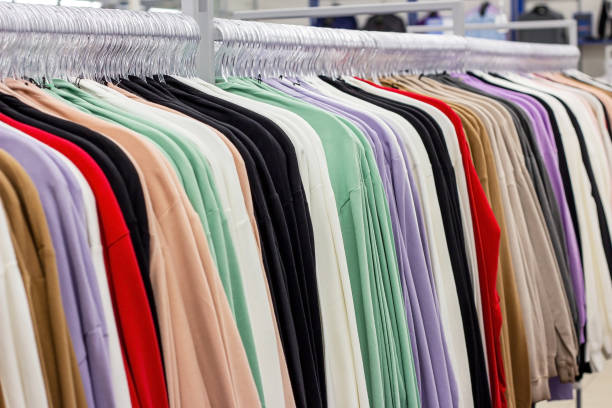 Different casual clothes hanging in the retail clothing store stock photo