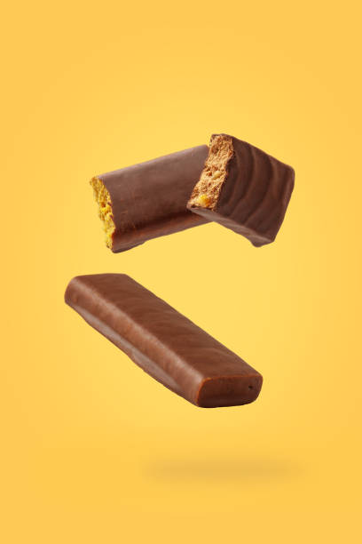 Different energy protein bar on yellow background. Flying levitation stock photo