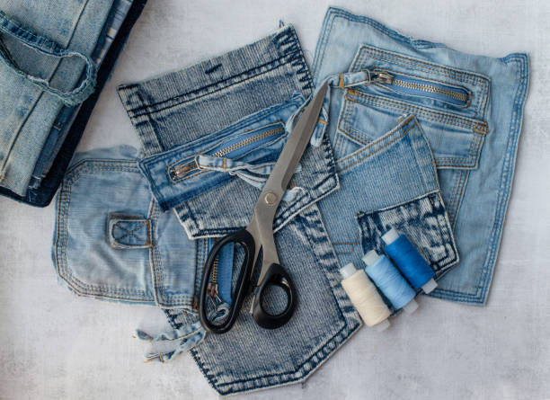 Different jeans pockets, scissors and threads ready to recycle. Different jeans pockets, scissors and threads ready to recycle. Concept of things reuse and natural resources preserving. upcycling stock pictures, royalty-free photos & images