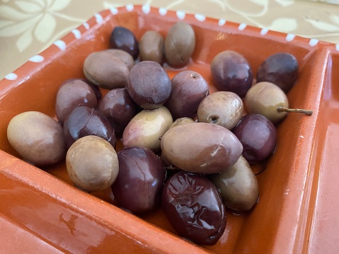 Close-up shot of natural olives brown clay bowl recipient.