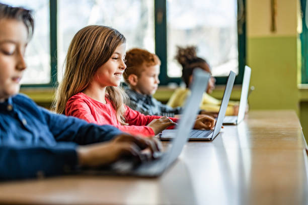 Digital native students e-learning over computers at school. stock photo