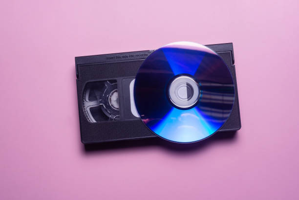 Digitalization concept VHS cassette and CD compact disk on the purple background top view. video digitization stock pictures, royalty-free photos & images