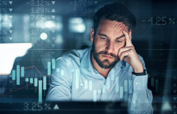 Digitally enhanced shot of a handsome businessman working in the office superimposed over a graph showing the ups and downs of the stock market stock photo