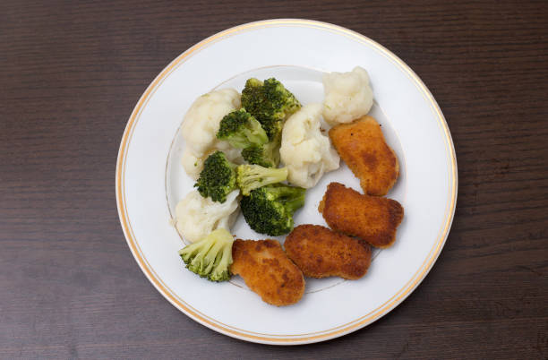 Dinner on a white plate that is on a dark background stock photo