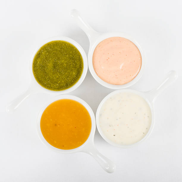 Dips Bowls of dipping sauces. Rose sauce, mint raita, coriander sauce and mango chutney. Shot from above on a white background. cocktail sauce stock pictures, royalty-free photos & images