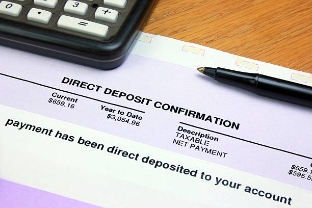 Direct Deposit Confirmation A direct deposit confirmation notice on a desk with a calculator and a pen. bank deposit slip stock pictures, royalty-free photos & images