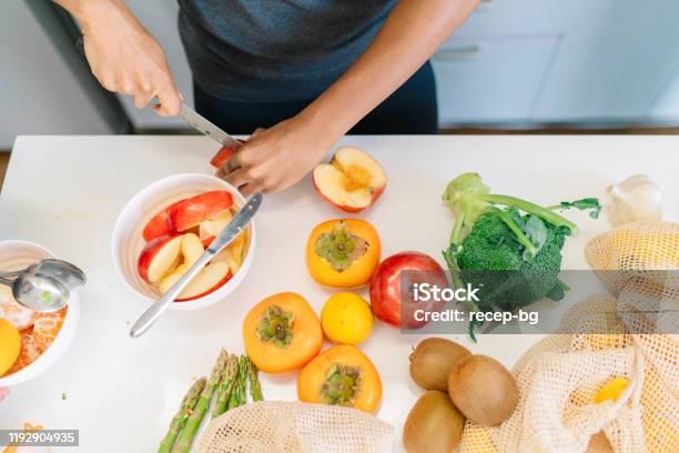 Directly above angle photo of oung woman's hands while preparing vegan food at home
