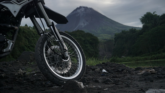 Dirt bike parked in front of a beautiful lake with Mount Merapi in the background. The name of this place is \