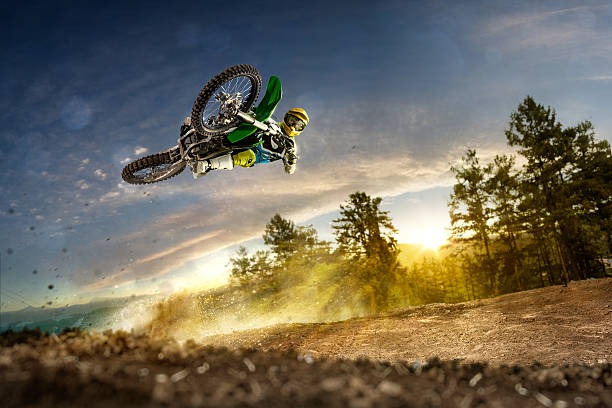 Dirt bike rider is flying high Dirt bike rider is flying high in evening extreme sports stock pictures, royalty-free photos & images