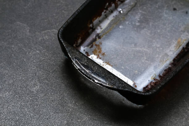 Dirty baking dish with thick layer of carbon. Glassware for baking with soot, carbon deposits, old dried fat. stock photo