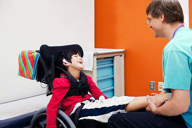 Disabled boy in wheelchair with his doctor stock photo