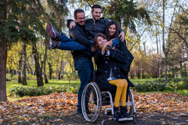 Disabled girl taking selfie with her friends in the park stock photo