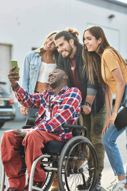 disabled man taking selfie with friends on street - wheelchair street happy imagens e fotografias de stock