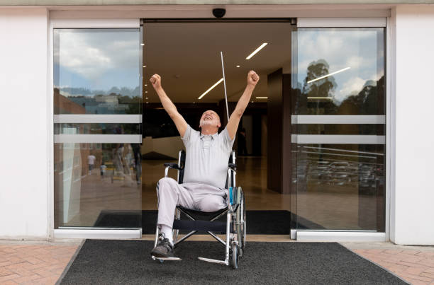 車椅子で退院する障害のある患者 - 退院 ストックフォトと画像