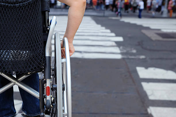 disabled person in wheelchair,crossing street - wheelchair street imagens e fotografias de stock