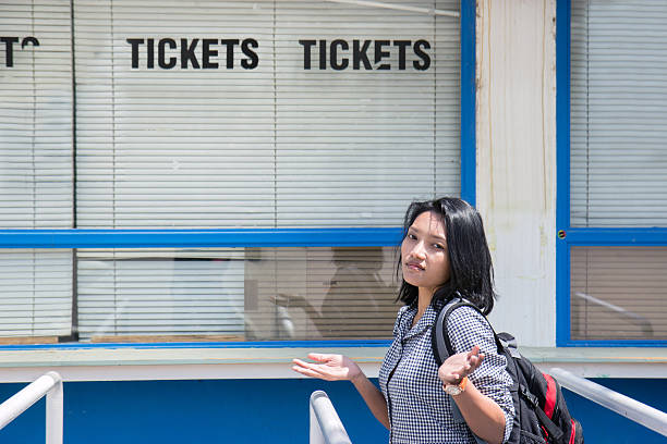 disappointed woman stands before the closed ticket office stock photo