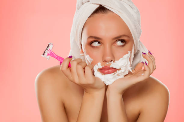 disappointed woman with foam on the face and a razor disappointed young woman with foam on the face and a razor in her hand women facial hairs stock pictures, royalty-free photos & images