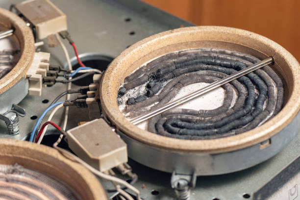 Disassembled electric burner with burned out heating elements, wires and cables stock photo