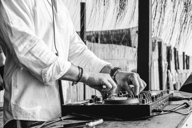 disc jockey playing music for tourist people at club party outdoors on the beach - dj at music live event - live event, music and fun concept - entertainment and party concept - focus on hands - beach game group stockfoto's en -beelden