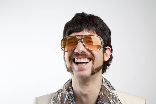 Disco Man Laughing Close up portrait of a retro man in a 1970s leisure suit and sunglasses smiling and laughing mutton chops stock pictures, royalty-free photos & images